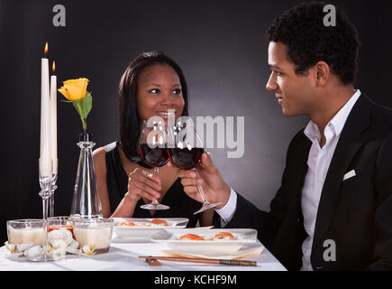 Ritratto di coppia romantica tostare il vino rosso a cena Foto Stock