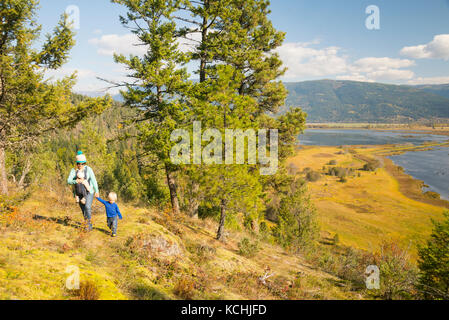Una donna escursioni con i suoi due bambini al di sopra della valle di Creston zone umide, British Columbia Foto Stock