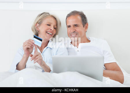 Matura in camera da letto Shopping Online Azienda Carta di Credito Foto Stock