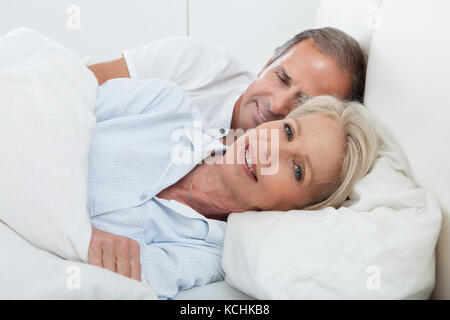 Ritratto di felice coppia Senior insieme a letto Foto Stock