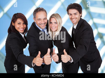 Ritratto di happy businessman che mostra il pollice fino a firmare Foto Stock