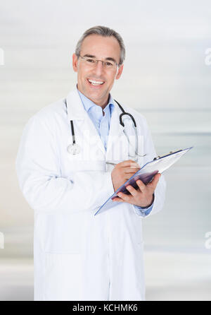 Ritratto di un felice medico iscritto negli appunti Foto Stock