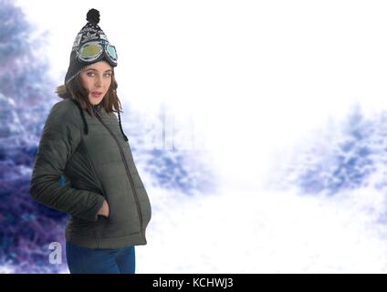 Digital composito della donna che indossa un cappello e ricoprire nella foresta di neve Foto Stock