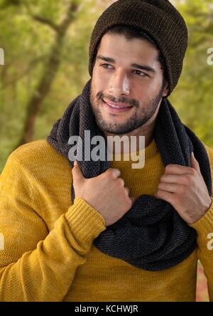 Composito Digitale dell uomo in autunno con il cappello e sciarpa in foresta Foto Stock