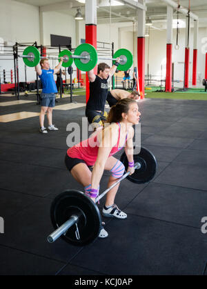 Determinare il sollevamento degli atleti barbells in palestra Foto Stock