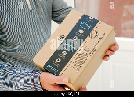 Primo piano di persona in possesso di un uomo che consegna un Amazon prime Order pacchetto pacco home internet shopping consegna Inghilterra Regno Unito Gran Bretagna Foto Stock