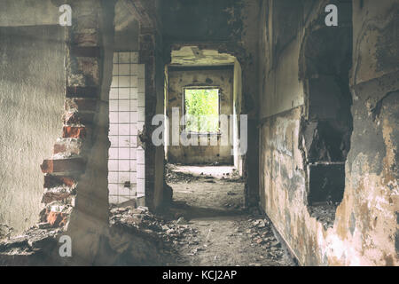 Edificio abbandonato urban exploration, raggi del sole cade sul flor nella vecchia casa abbandonata. Urbex di spooky e inquietante vecchia fabbrica. Foto sbiadite Foto Stock