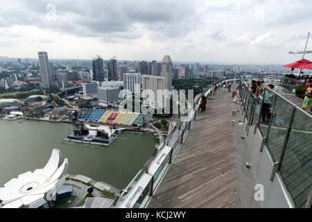 I visitatori ammirano le vedute circostanti della citta' di Singapore dall'alta piattaforma di osservazione del Marina Bay Sands Hotel Foto Stock