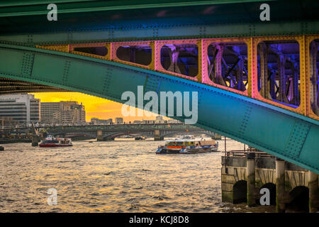 Dettagli dipinti della struttura del Southwark Bridge incornicia le barche sul Tamigi Foto Stock