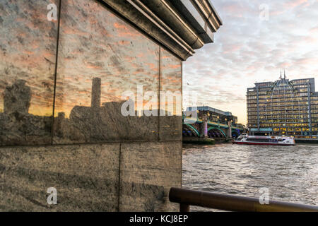 London skyline della città si riflette nella colonna di marmo vicino al fiume Tamigi Foto Stock