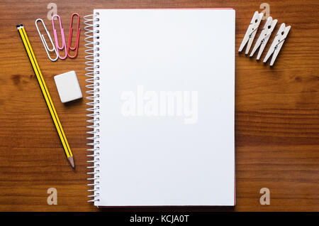 Penna, notepad e carica gli oggetti sul tavolo di legno Foto Stock