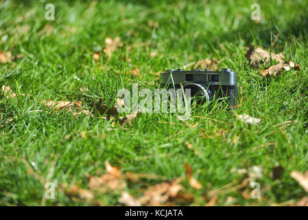 Il vecchio analogico vintage telemetro fotocamera foto in natura autunno sfondo di erba Foto Stock