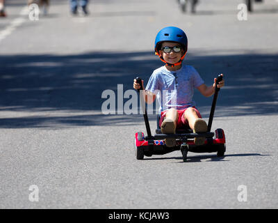 Felice ragazzo in piedi su hoverboard o gyroscooter con kart kit di accessori outdoor. nuove tecnologie moderne Foto Stock