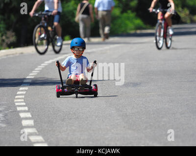 Felice ragazzo in piedi su hoverboard o gyroscooter con kart kit di accessori outdoor. nuove tecnologie moderne Foto Stock