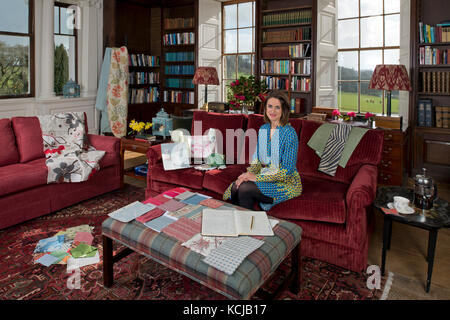 Interior designer Sarah Fortescue nel suo ufficio, la biblioteca della Casa Boconnoc, Cornwall, la casa di famiglia. Foto Stock