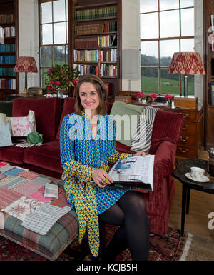 Interior designer Sarah Fortescue nel suo ufficio, la biblioteca della Casa Boconnoc, Cornwall, la casa di famiglia. Foto Stock