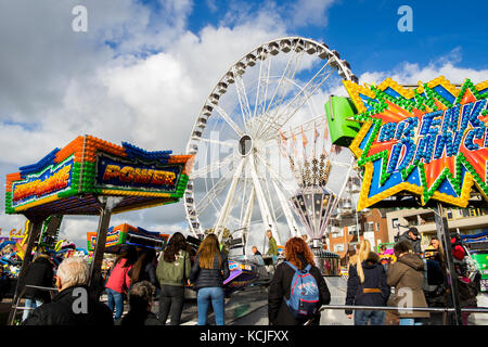 Leiden, Paesi Bassi il 3 ottobre 2017. La fiera locale parco divertimenti con attrazioni, persone e un gigantesco ferriswheel in background. editorial Foto Stock