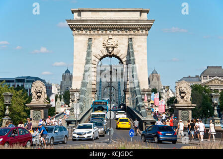 Dal lato Buda di Budapest una vista prospettica compressa di turisti, traffico, auto, veicoli che entrano e lasciano il Ponte delle catene a Budapest. Foto Stock