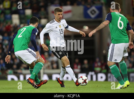 Belfast, Irlanda del Nord. 5 ottobre 2017. Il tedesco Thomas Mueller (c) e l'irlandese Conor McLaughlin (l) e Lee Hodson in azione durante la partita di qualificazione del gruppo C della Coppa del mondo tra l'Irlanda del Nord e la Germania a Belfast, Irlanda del Nord, 5 ottobre 2017. Credito: Christian Charisius/dpa/Alamy Live News Foto Stock