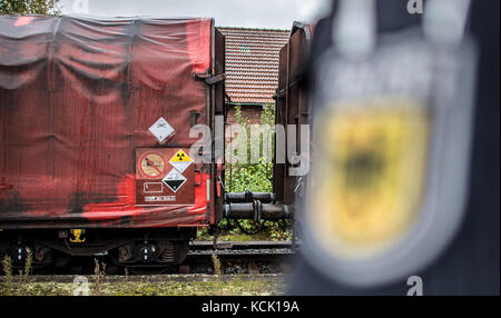 Ochtrup, Germania. 6 ottobre 2017. Un agente di polizia si trova sul piano della stazione di Ochtrup, in Germania, il 6 ottobre 2017. Un treno con rifiuti radioattivi passa. Vicino a Gronau, nella regione di Muensterland, gli attivisti hanno bloccato i binari di un treno per oltre undici ore. Volevano fermare un treno che raggiungesse l'impianto di lavorazione dell'uranio di Gronau. Il percorso è stato chiuso fino alle prime ore del mattino. Crediti: Guido Kirchner/dpa/Alamy Live News Foto Stock