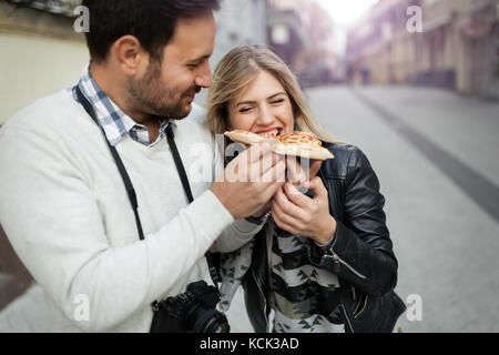 Giovane coppia attraente la condivisione di un trancio di pizza Foto Stock