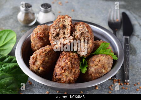 Polpette con grano saraceno in una ciotola di metallo su un grigio Sfondo astratto.il cibo sano.mangiare sano concetto Foto Stock