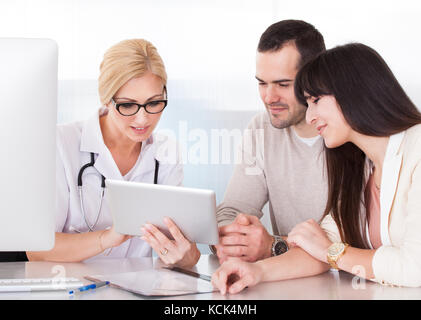 Felice medico discutendo con la giovane in clinica Foto Stock