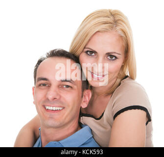 Giovane uomo Piggybacking donna su sfondo bianco Foto Stock