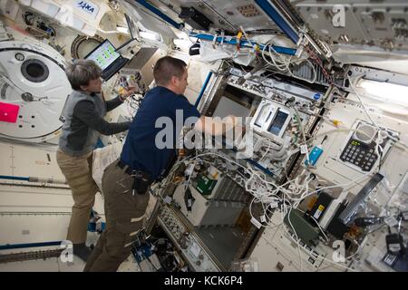 La NASA International Space Station Expedition 51 membri dell'equipaggio gli astronauti americani Peggy Whitson (a sinistra) e Jack Fischer lavorano all'interno del modulo giapponese Kibo Laboratory Module 1 agosto 2017 in orbita terrestre. (Foto della NASA foto via Planetpix) Foto Stock