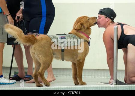 Christina Gardner, veterano dell'esercito americano, riceve un bacio dal suo cane di servizio militare Moxie dopo aver partecipato a una gara di nuoto durante i Giochi Guerrieri del Dipartimento della difesa presso l'Università dell'Illinois l'8 luglio 2017 a Chicago, Illinois. I DoD Warrior Games consentono a soldati e veterani feriti, malati e feriti di competere in sport in stile paralimpico. (Foto di Roger L. Wollenberg via Planetpix) Foto Stock