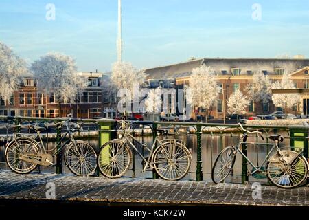 Coperta di neve biciclette parcheggiate lungo la catharinjnebrug in haarlem, Paesi Bassi. Foto Stock