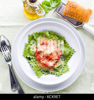 Il piatto con il cibo italiano, ravioli o tortelli sul tavolo. formaggio e vino e vino rosso nella Wineglass. stile a molla Foto Stock