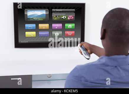 L'uomo africano remoto di contenimento nella parte anteriore del televisore Foto Stock