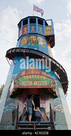 L uomo e la giovane ragazza entra in un Helter Skelter a Malvern autunno mostra, Worcestershire, Regno Unito Foto Stock