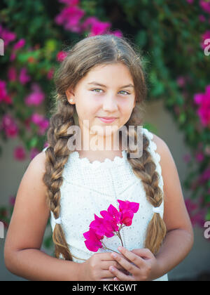 Bella ragazza giovane con trecce su sfondo natura Foto Stock