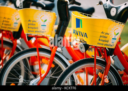 Vilnius, Lituania - 5 luglio 2016: fila di biciclette colorate di Aviva in affitto a livello comunale parcheggio bici in strada. giorno di estate Foto Stock