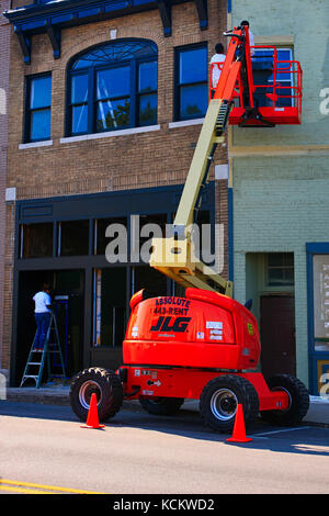 Gli uomini utilizzano un cherry picker per dipingere la parte esterna di un negozio nel centro di Libano Tn, STATI UNITI D'AMERICA Foto Stock