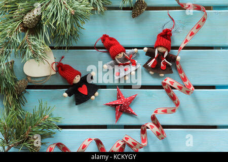 Collezione di ornamenti natale su blu il colore di sfondo in legno incorniciata con abete rami Foto Stock