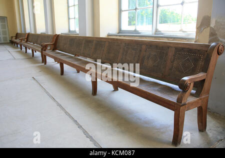 Antiquariato lunga panca di legno in una chiesa Foto Stock