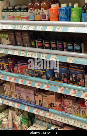 Un display sui ripiani del cane e del gatto i trattamenti degli animali e dei prodotti di pulizia in vendita in un grande high street pet rivenditore di materiali di consumo. La cura per animali domestici. Foto Stock