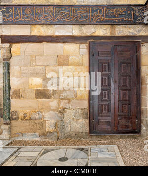 In legno porta ornati oltre il muro di pietra al mausoleo di al-salih nagm ad-din ayyub al Cairo, Egitto Foto Stock