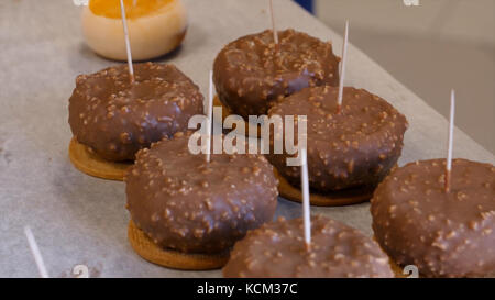 Cheesecake alla ciliegia sul tavolo. Per le vacanze vengono servite una selezione di mini torte di cioccolato e frutta. Torte di frutta con frutti di bosco. Torta a strati di spinaci e pila di macaron francesi. Foto Stock