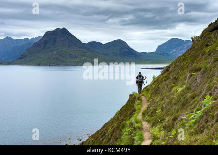 Un camminatore sul sentiero costiero da Elgol a Camasunary, lungo Loch Scavaig, Isola di Skye, Scozia, Regno Unito. Sgurr na Stri a sinistra e Marsco a destra. Foto Stock