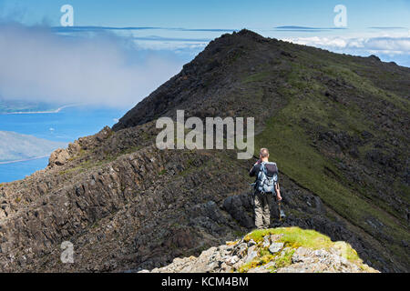 Un camminatore sulla cresta sommitale di Bla Bheinn, che parte dalla cima più bassa orientale fino alla cima principale. Isola di Skye, Scozia, Regno Unito. Foto Stock