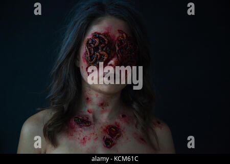 Ragazza con piaghe realistica e worm nei suoi occhi. creative Halloween trucco. Foto Stock