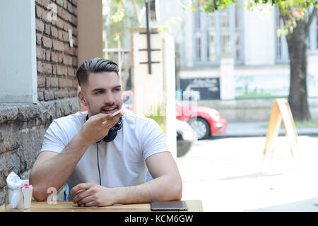 Ritratto di giovane uomo latino invio di messaggi vocali. all'esterno. scena urbana. Foto Stock