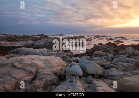 Paesaggio roccioso lungo la penisola di Monterey, costa californiana, al tramonto. Foto Stock