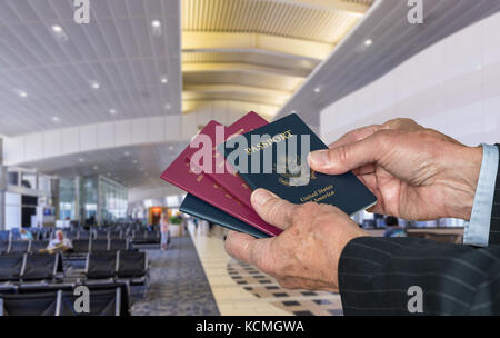 Senior Executive braccio scegliendo un passaporto al terminal aeroportuale Foto Stock