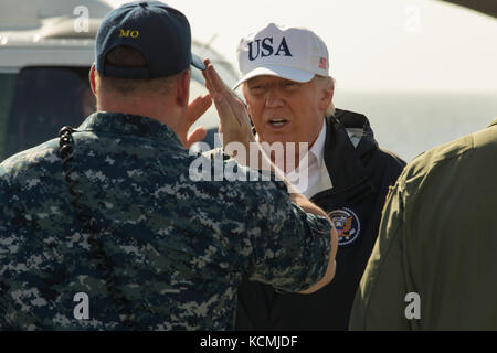 Presidente Donald Trump restituisce un saluto da Lt. La Cmdr. Todd Dupree sul ponte di volo Foto Stock