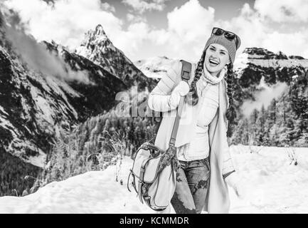 Inverno sul livello superiore di divertimento. ritratto di felice donna elegante contro il paesaggio di montagna in alto adige, italia Foto Stock